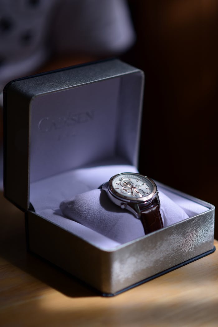 Stylish wristwatch with leather strap in an elegant presentation box, subtly lit, perfect for gifting.